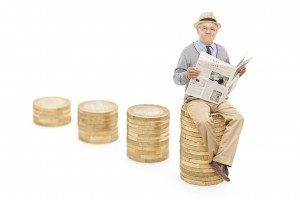 Senior reading the news seated on a pile of coins